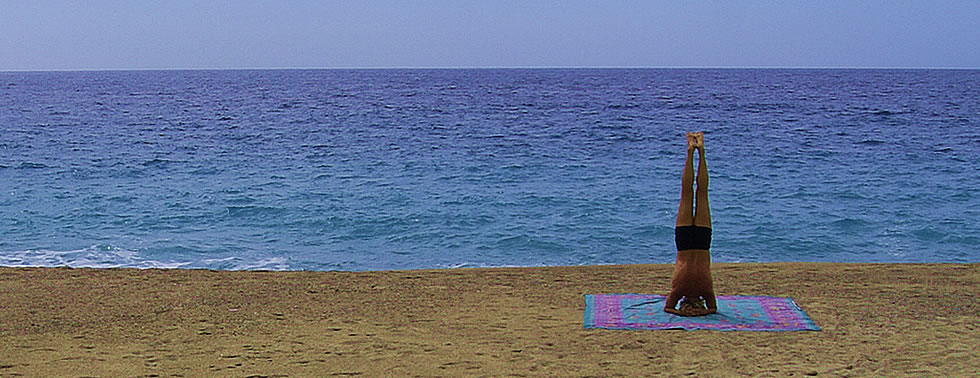 Königsstellung der Kopfstand oder Sirshasana am Strand von Korsika