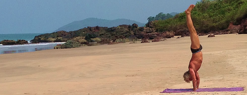 Handstand oder Adho Mukha Vrikshasana am Strand von Galgibaga, Indien