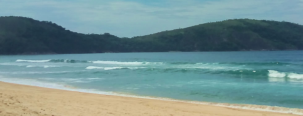 Meeresstrand mit Hügeln im Hintergrund